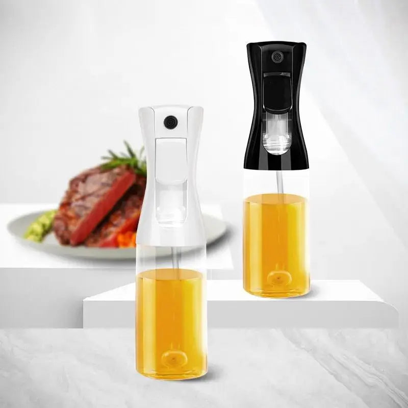 Two Oil & Vinegar Spray Bottles (black and white) filled with oil, placed on a modern kitchen surface with a plated steak in the background.